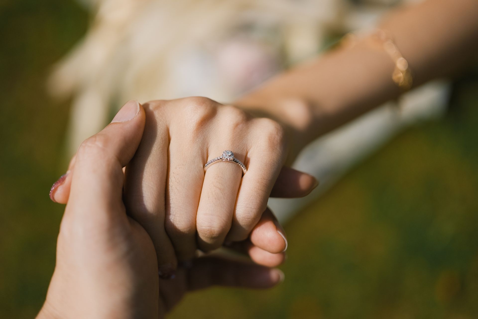 Hand wearing a silver-colored solitaire ring