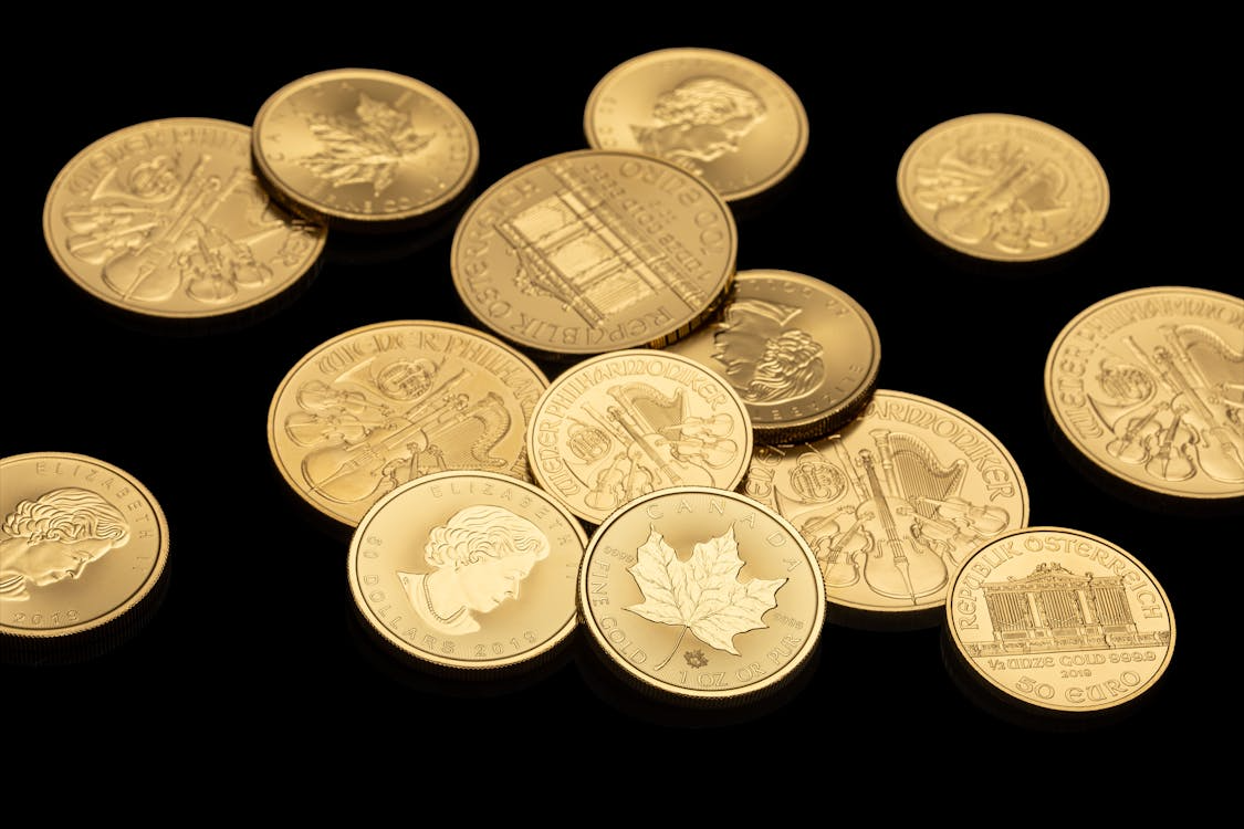 several gold coins against a black background